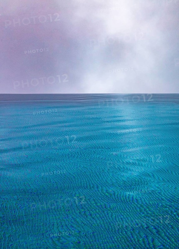 Rippled water surface during rain in swimming pool with dramatic cloudy sky