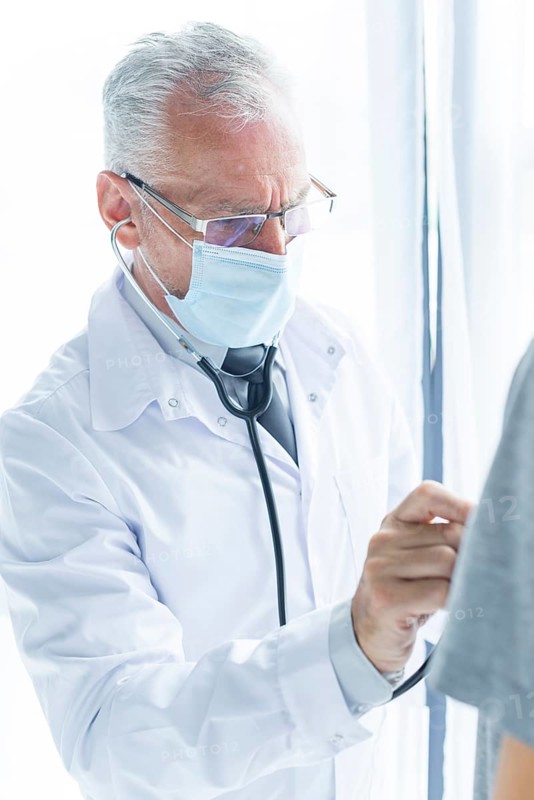 Doctor mask examining crop patient