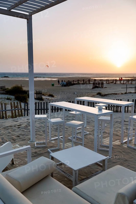 White tables and chairs in the sand