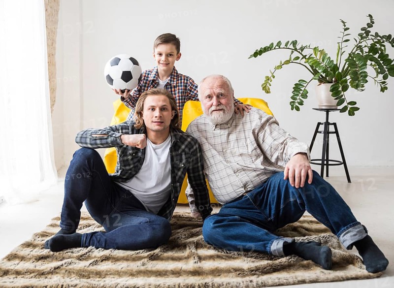 Men sitting carpet watching soccer