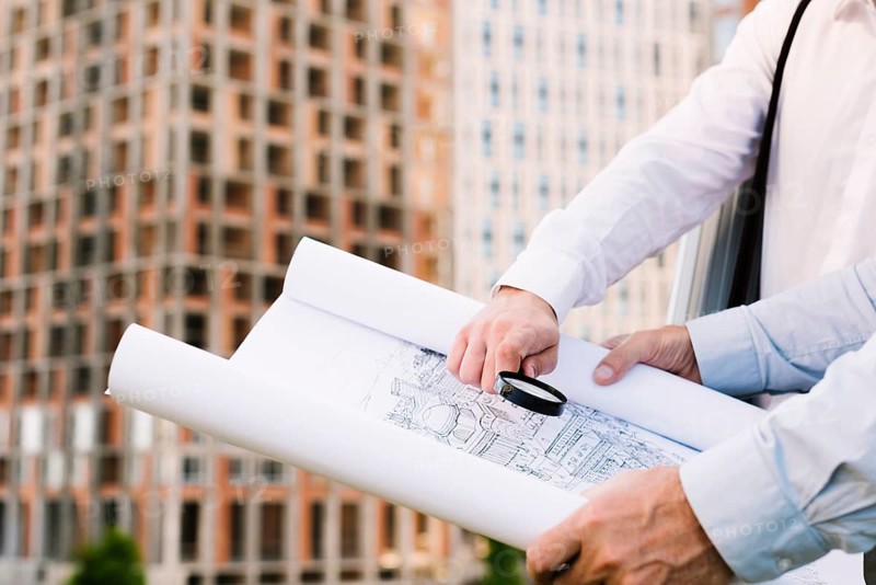 Close up people holding building sketch