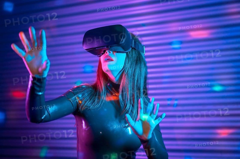 Female gamer wearing augmented reality goggles in a futuristic space with neon lights