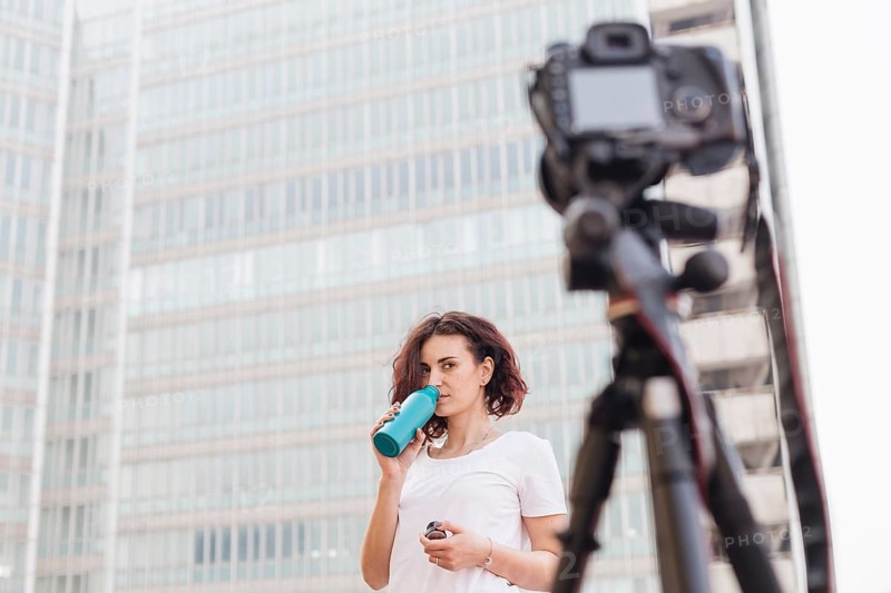 Brunette blogger drinking water from bottle