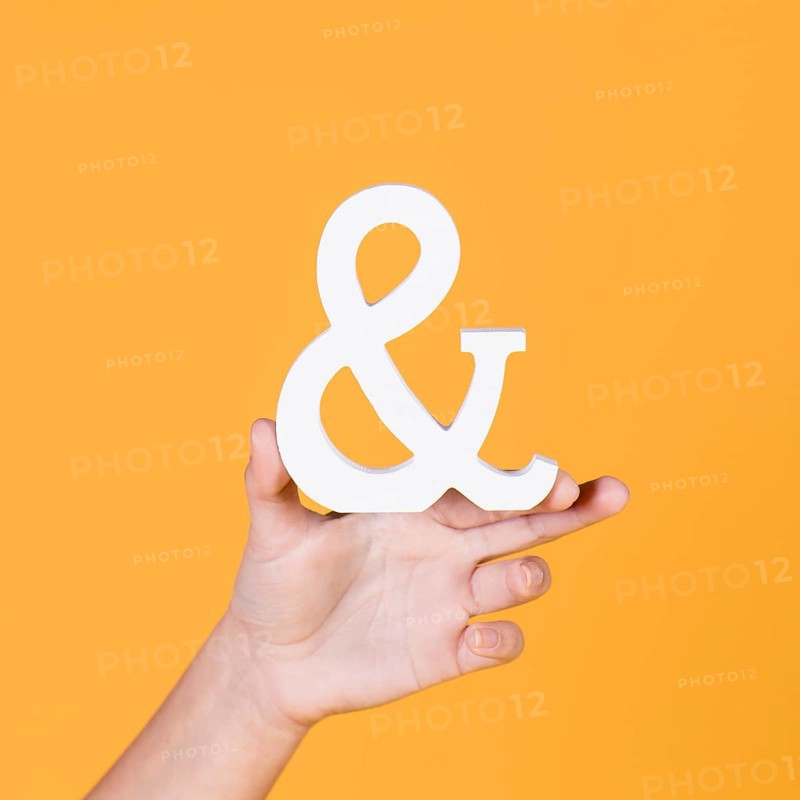 Woman s hand holding sign yellow background