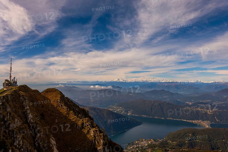 Aerial View over a Beautiful Meteorological and Communication Station on Mountain Peak and Snow Capped Monte Rosa and Lake Lugano in a Sunny Day in Monte Generoso
