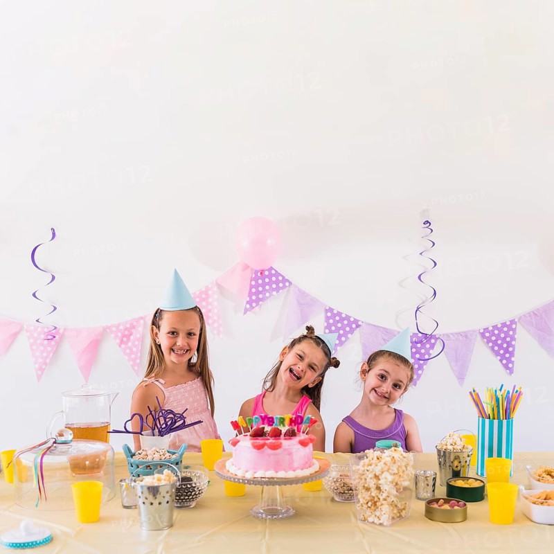 Happy friends enjoying birthday party with tasty snack cake table