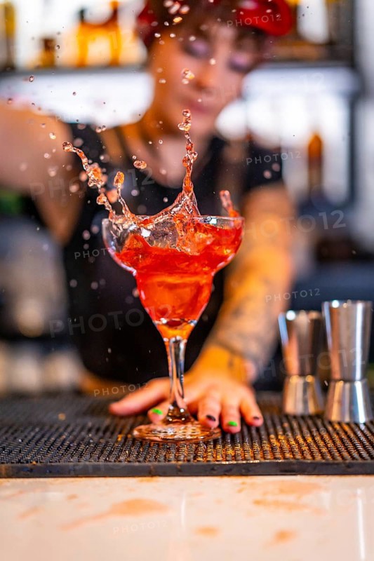 Vertical photo of a professional bartender preparing a Sex on the beach cocktail