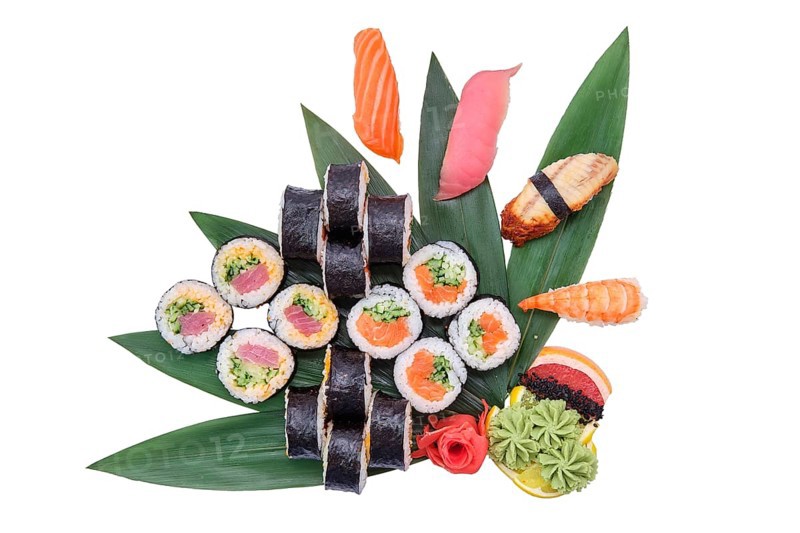 Overhead view of big set of sushi and rolls served on bamboo leaves