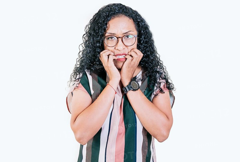 Worried young woman biting her nails isolated. Anxious afro woman biting her nails