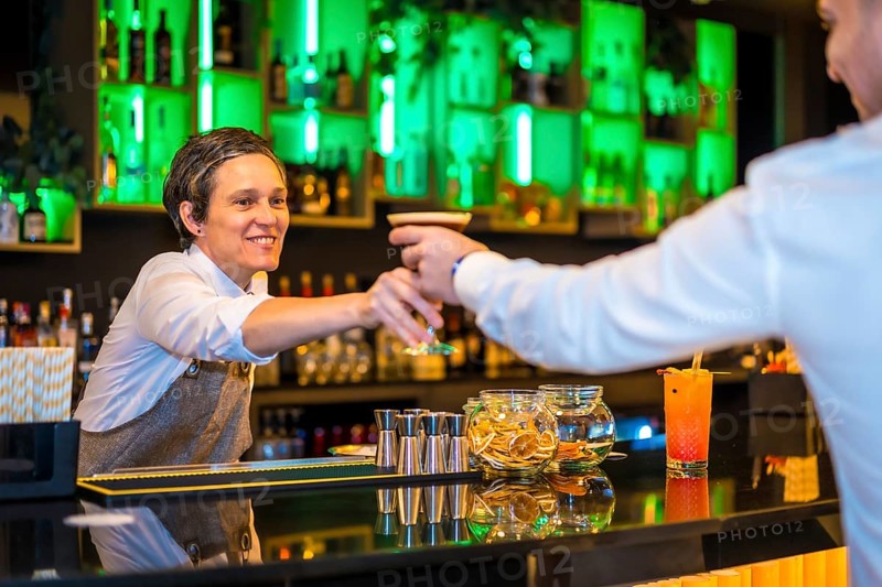 Bartender serving a martini cocktail in a luxury bar to a man