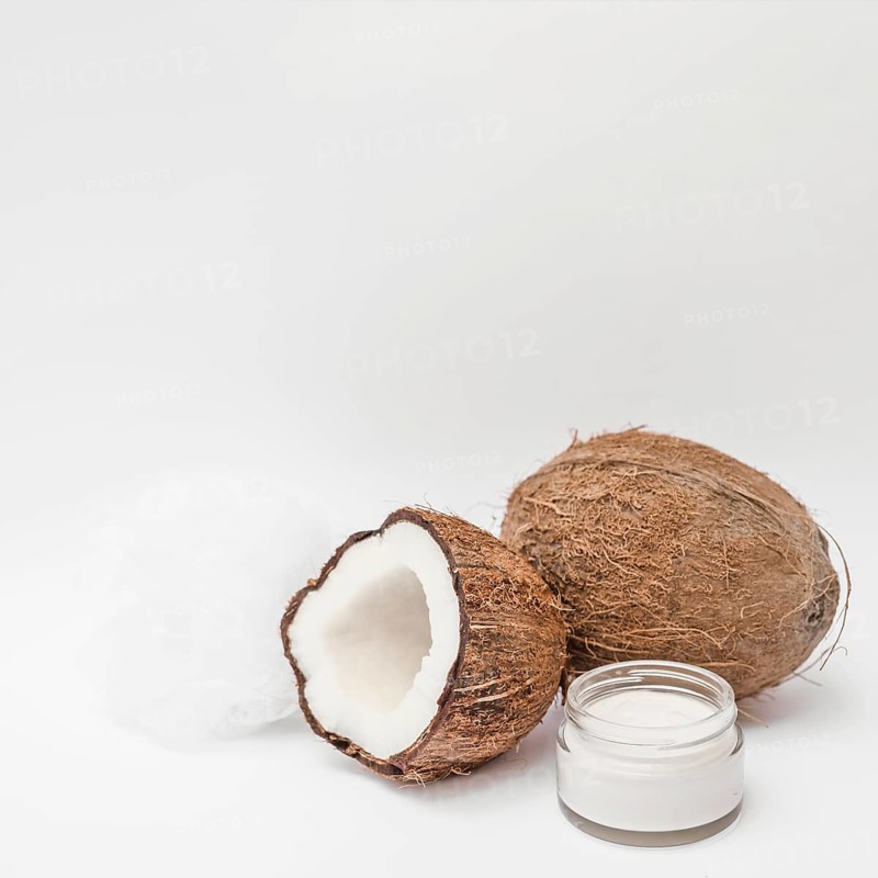 Close up moisturizing cream loofah coconut white backdrop