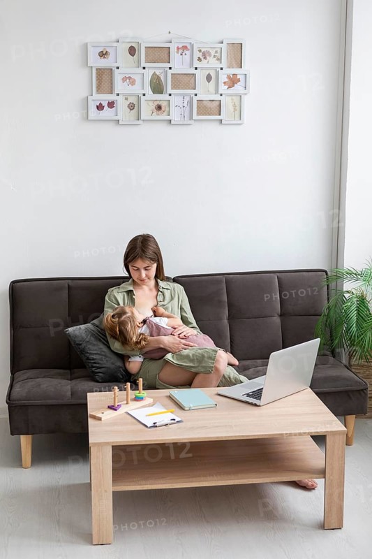 Full shot mother breastfeeding girl