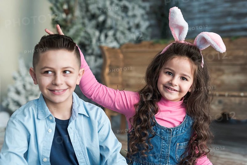 Girl bunny ears making horns with fingers boy