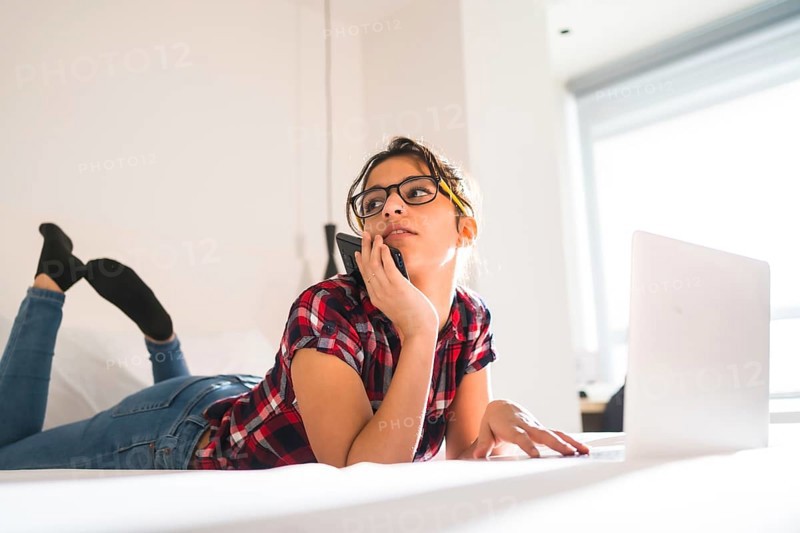 Low angle view of a beauty distracted woman working from an hotel room