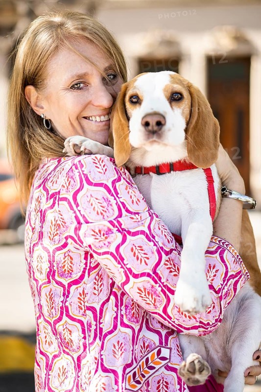Female hugging friendly beagle dog enjoying happy moments while both look at camera