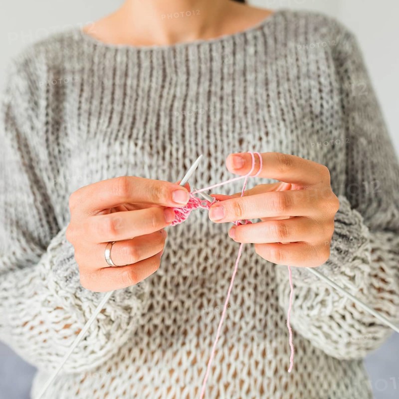 Close up female s hand crocheting with pink thread