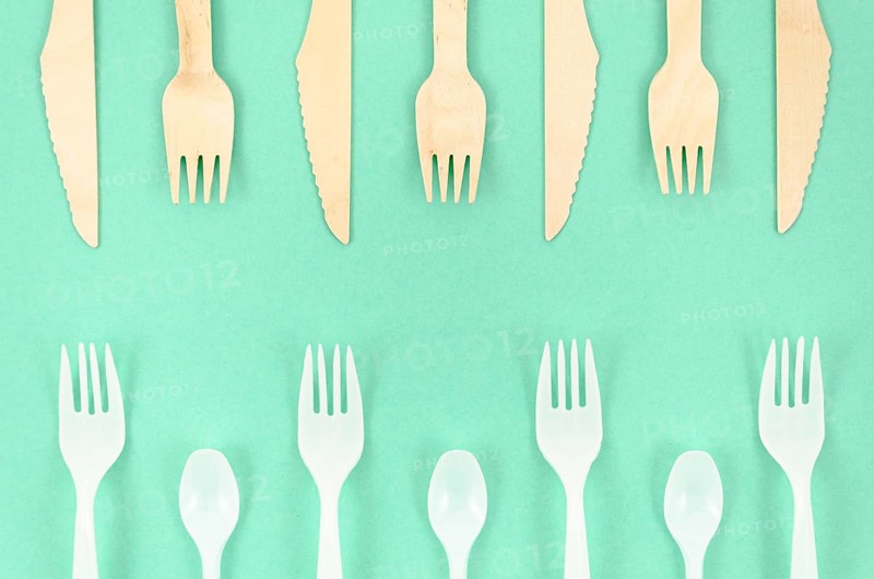 Colorful disposable cutlery turquoise background