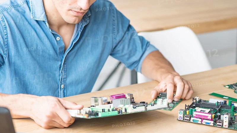 Close up hardware engineer repairing motherboard