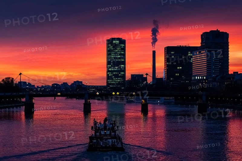 A ship sails along the Main towards Frankfurt's Westhafen harbour in the evening. The office lights are lit up in the Westhafen Tower