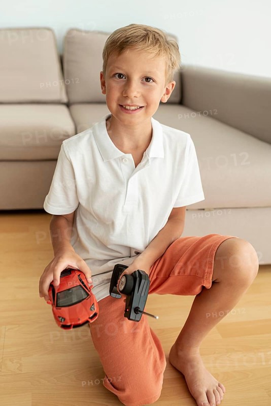 Front view kid playing with electric car