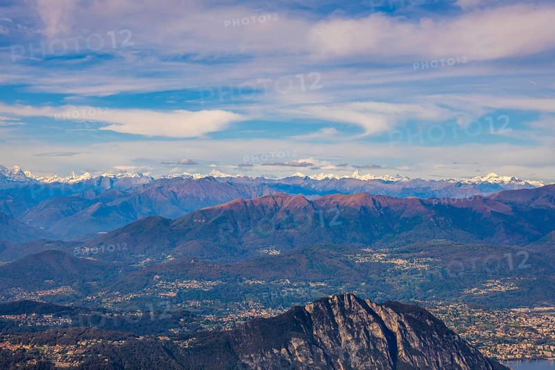 Aerial View over a Beautiful Mountainscape and And Snow Capped Mountain and with Floating Clouds in a Sunny Day in Lugano