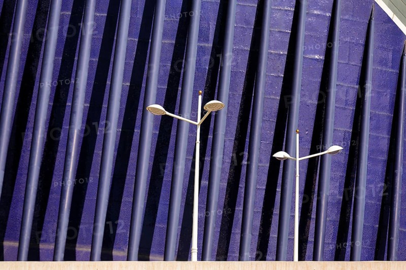 Streetlights in front of a blue facade