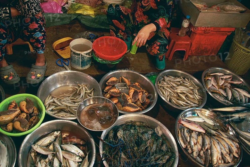 Overhead view of two vendor selling fresh seafood in the local traditional Samaki wet market in Kampot Cambodia