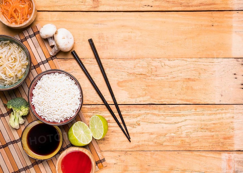 Elevated view mushroom sprout beans rice broccoli lemon sauce with chopsticks against wooden desk