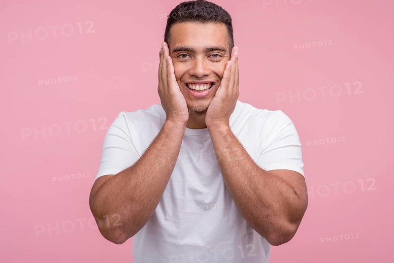 Front view smiley handsome man posing with palms his face