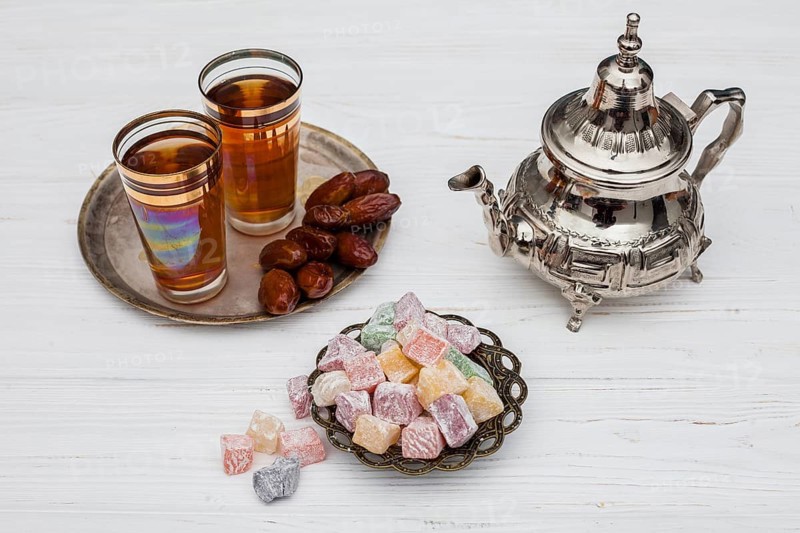 Heap dry dates near cups tea turkish delights teapot