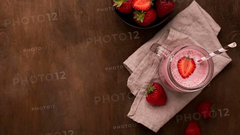 Flat lay strawberry milkshake with straw copy space