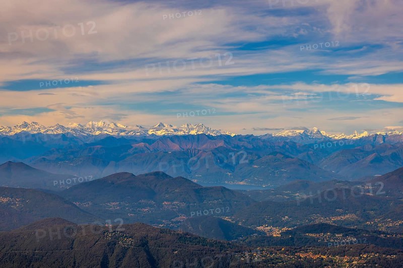 Aerial View over a Beautiful Mountainscape and And Snow Capped Mountain and with Floating Clouds in a Sunny Day in Lugano