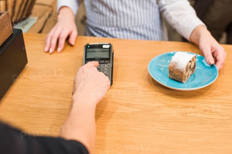 Close up customer using pin machine pay bill delicious cake slice