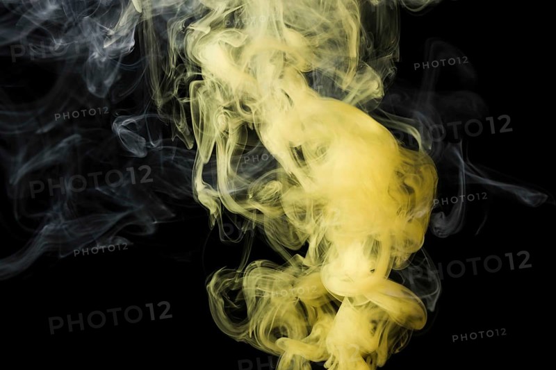 Close up yellow smoke against black background