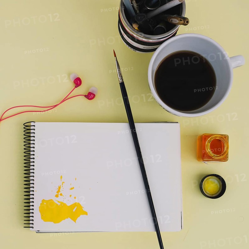 Brush notebook near coffee earphones