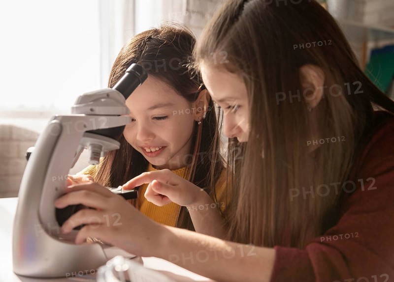 Girl learning with microscope close up