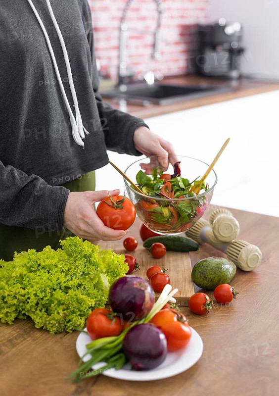 Close up hand holding bowl with tasty salad