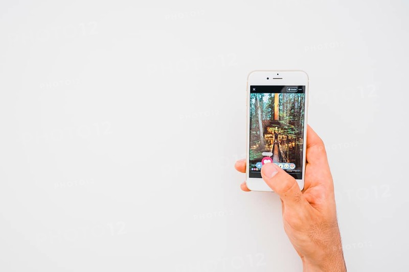 Hand holding phone with facebook copy space
