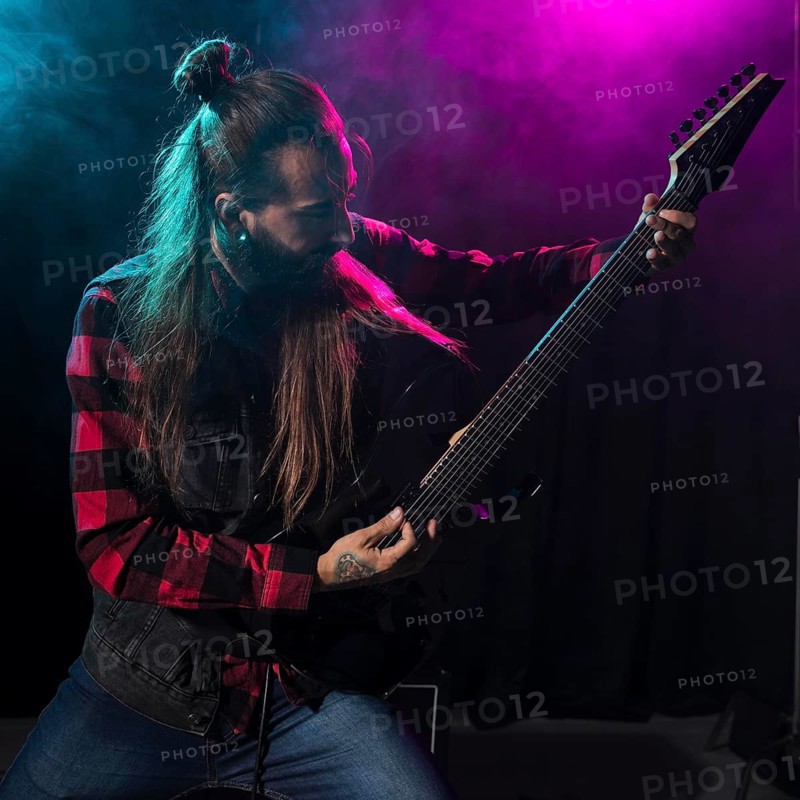 Artist playing guitar looking instrument