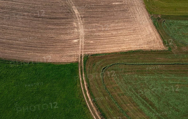 Drone view of green and ploughed fields with field path near Pabneukirchen