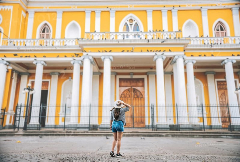 Rear view of tourist girl looking at cathedral. Tourist woman from back looking at a cathedral in a square. Granada