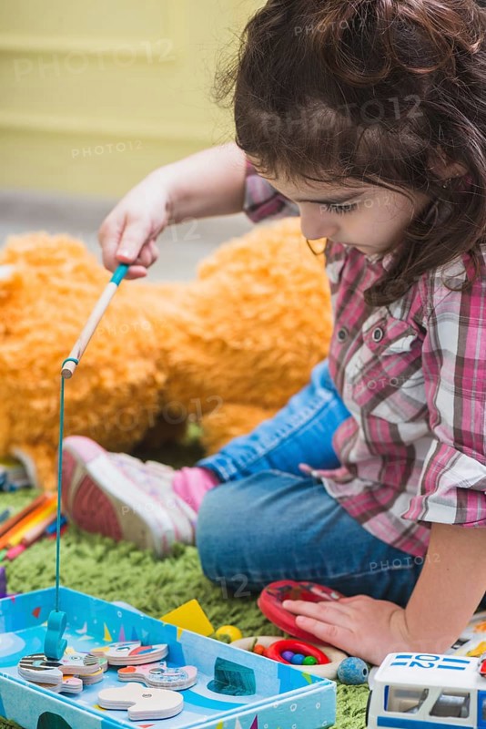 Girl playing with toy fishing rod