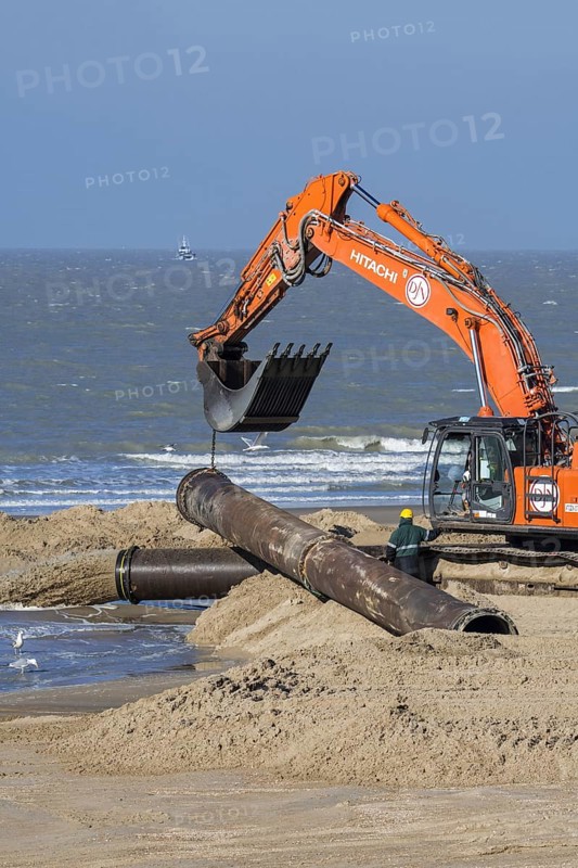 Hydraulic excavator installing pipeline during sand replenishment