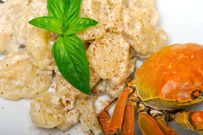 Fresh homemade Italian gnocchi with seafood sauce crab and basil