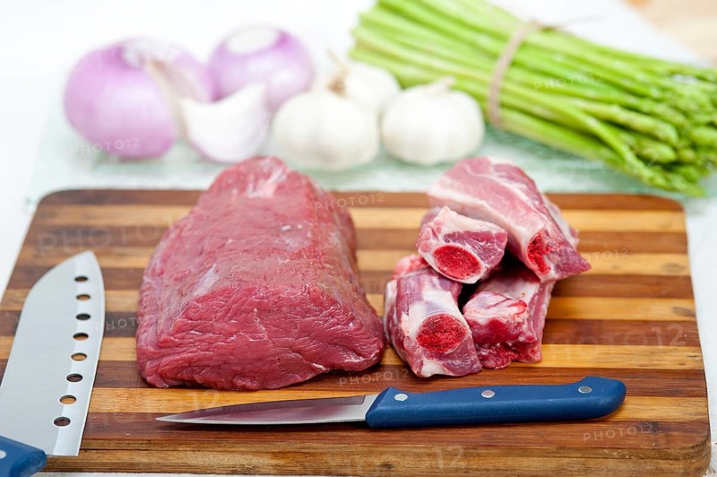 Raw beef and pork ribs with asparagus and herbs ready to cook