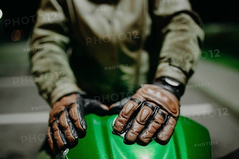 A motorcyclist shows his leather brown gloves for a touring trip to the camera