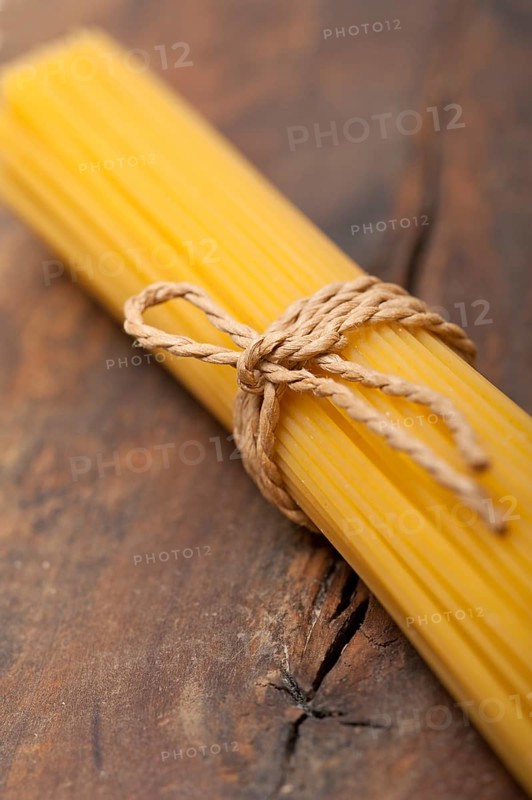 Italian pasta spaghetti tied with a rope on a rustic table