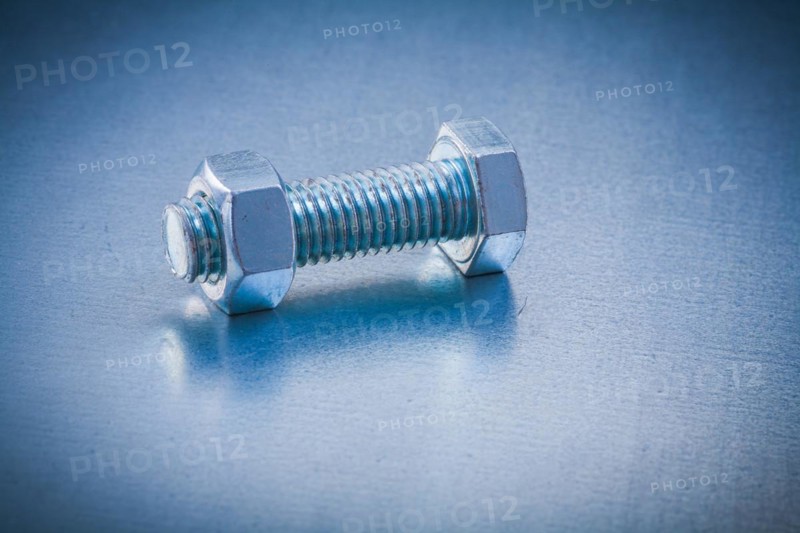 Stainless steel bolt detail with screw nut on metallic background Construction concept