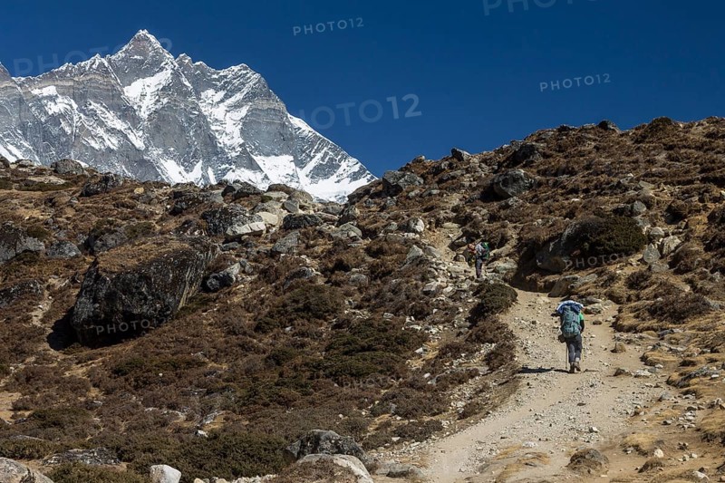 An independent trekker approaching Dingboche on a trek in the Everest Region. Lhotse