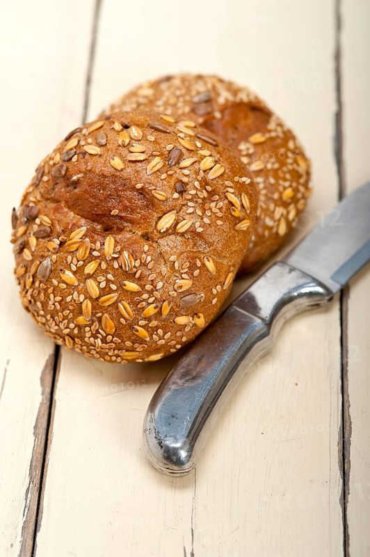 Fresh organic bread over rustic table macro closeup